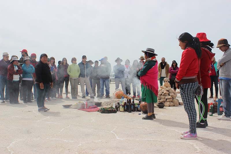 Miembros de comunidades, funcionarios, y turistas en la ceremonia de la Pachamama.