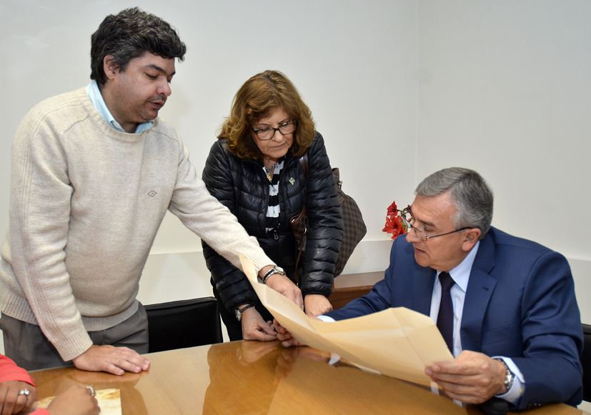 El gobernador con la decana y el secretario adjunto de la Facultad de Ciencias Económicas observando el proyecto de obra de la institución. 