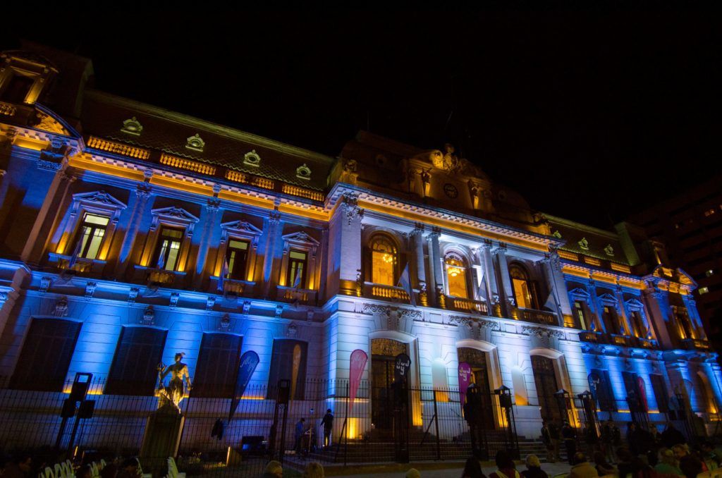 Casa de Gobierno iluminada con colores patrios y embanderada.