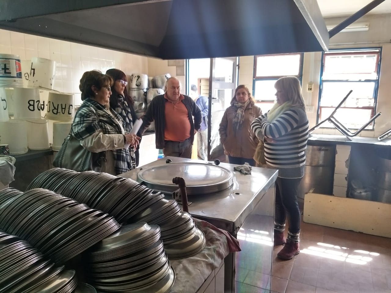 La secretaria Brajcich y la directora de Mantenimiento Murillo observan las instalaciones de la cocina, junto a personal directivo de la escuela de Aguas Calientes.